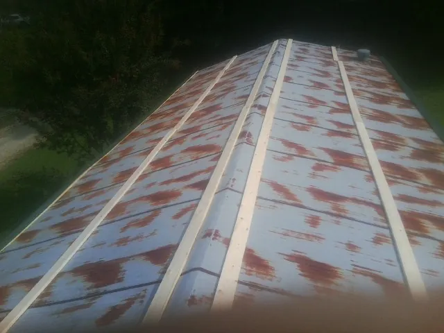 Rusted metal roof panels with new wood purlins before replacement — Storm Damage Roof Repair in Diagonal by Roofing Brothers