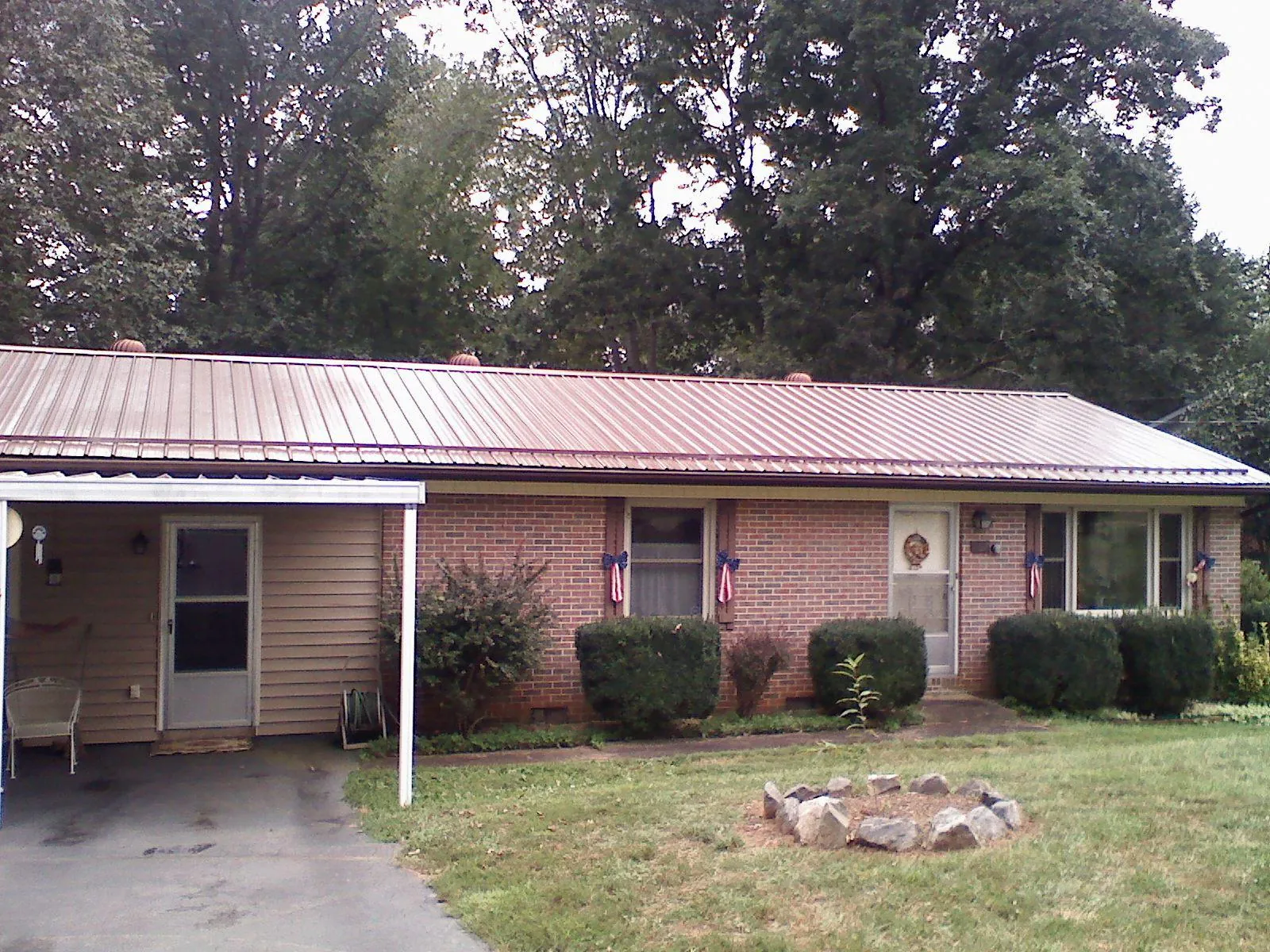 Bronze metal roof and carport on a brick ranch home — Roof Repair work by our crew in Diagonal